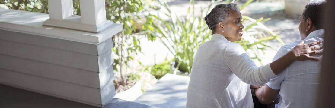 Retired couple sitting together on a porch, representing support and stability through Social Security survivor benefits.
